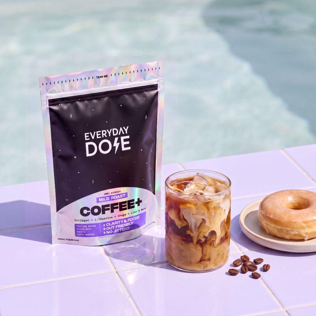 Everyday Dose Coffee+ Mild Roast on pool tiles with iced coffee, glazed donut and coffee beans
