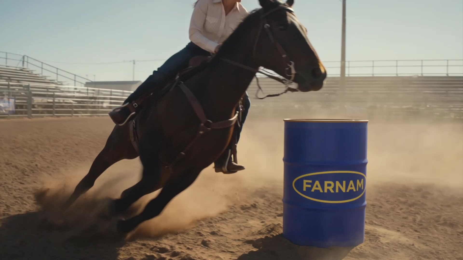 Farnam Apple Elite - Barrel racer cutting tight around a blue Farnam barrel, dust in the air