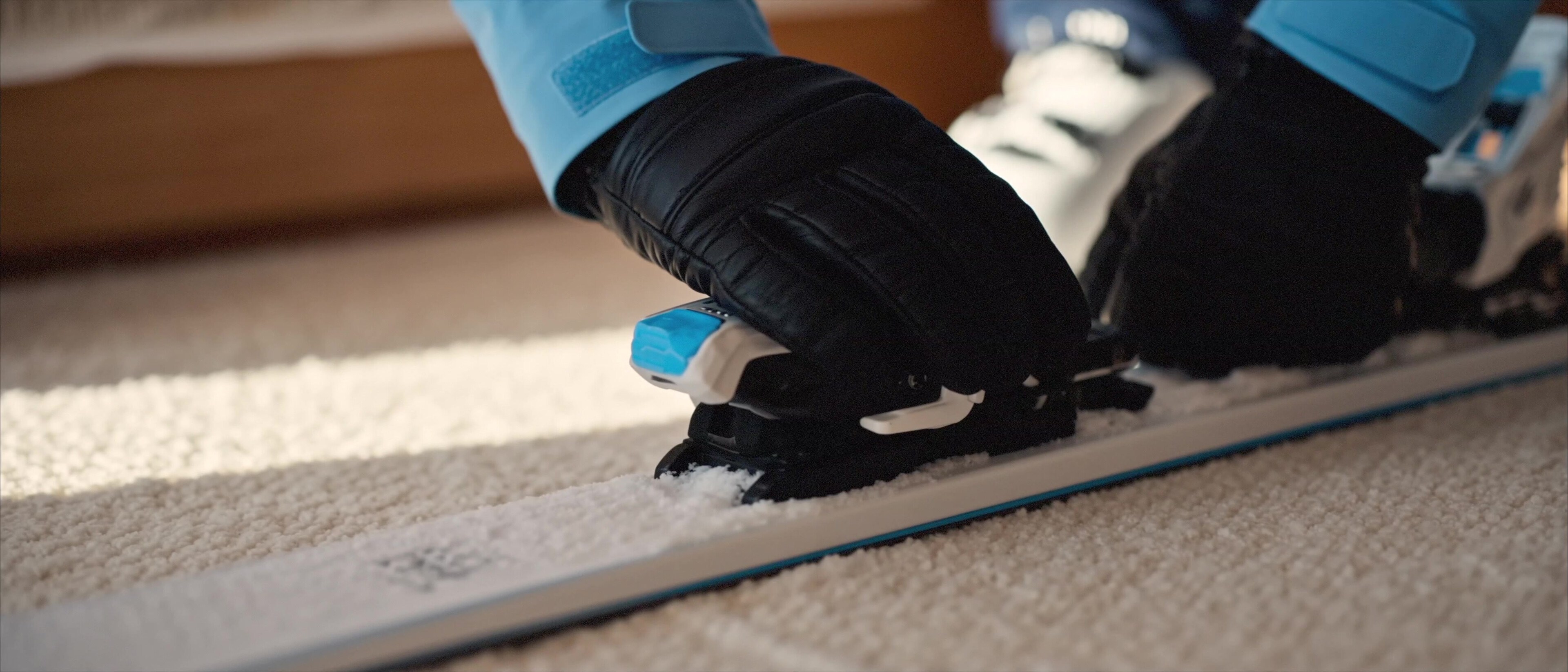 Moccamaster ICE - Gloved hands clicking into ski bindings on the chalet floor