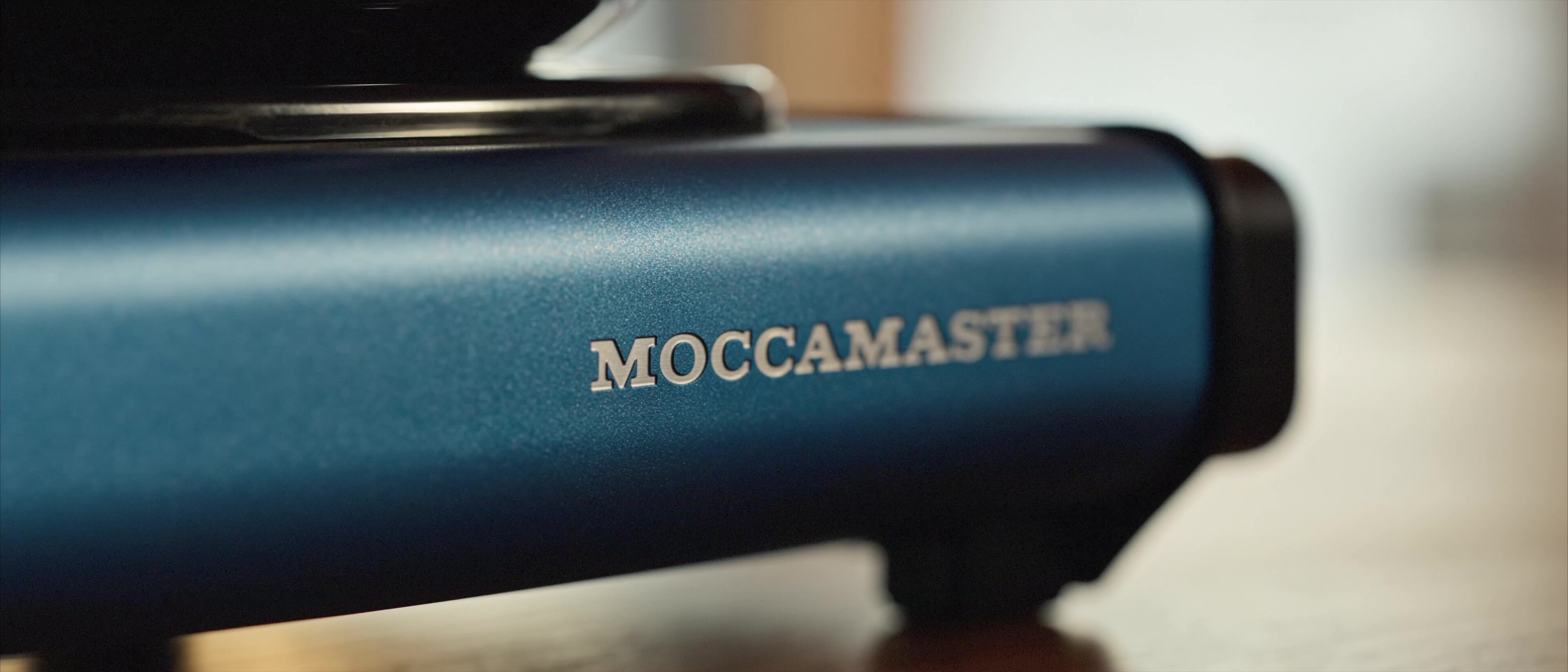 Moccamaster ICE - Macro of the Moccamaster wordmark on the brushed blue base