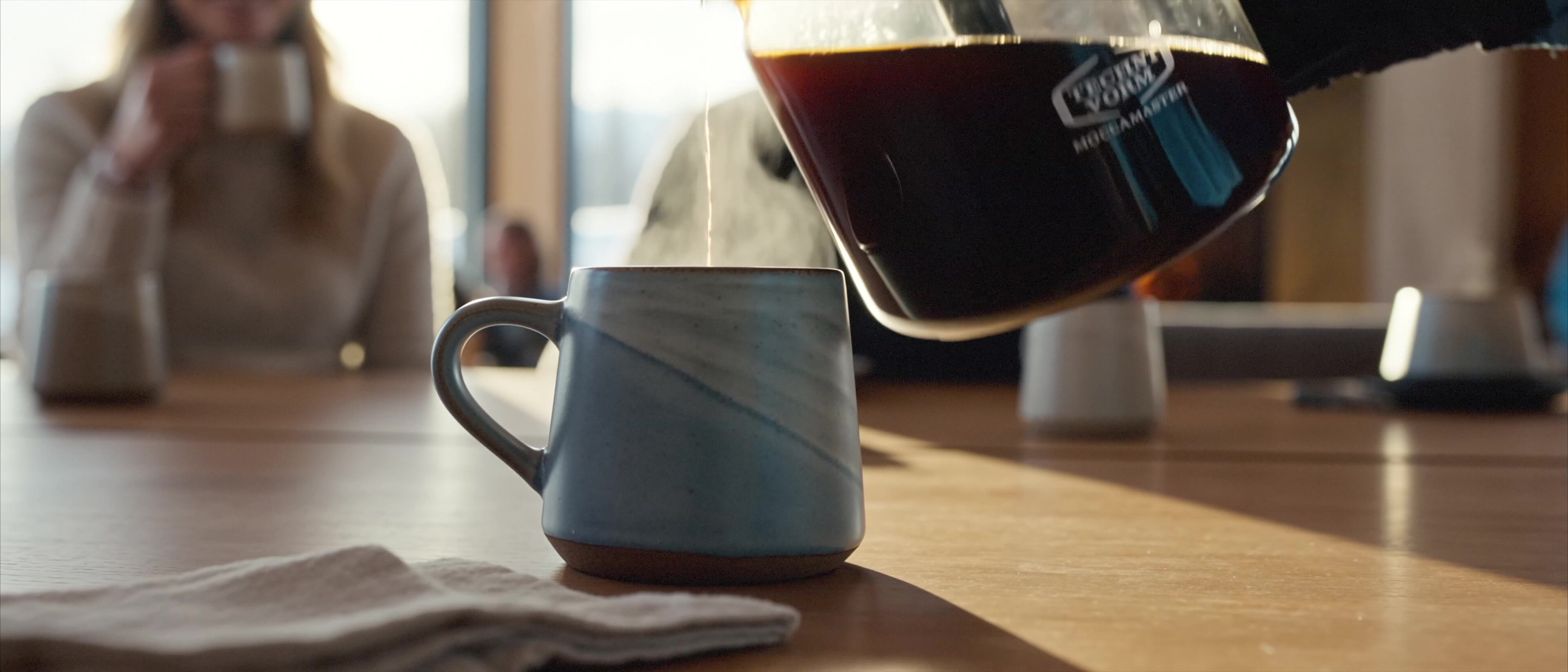 Moccamaster ICE - Steam rising from a full mug on the chalet table