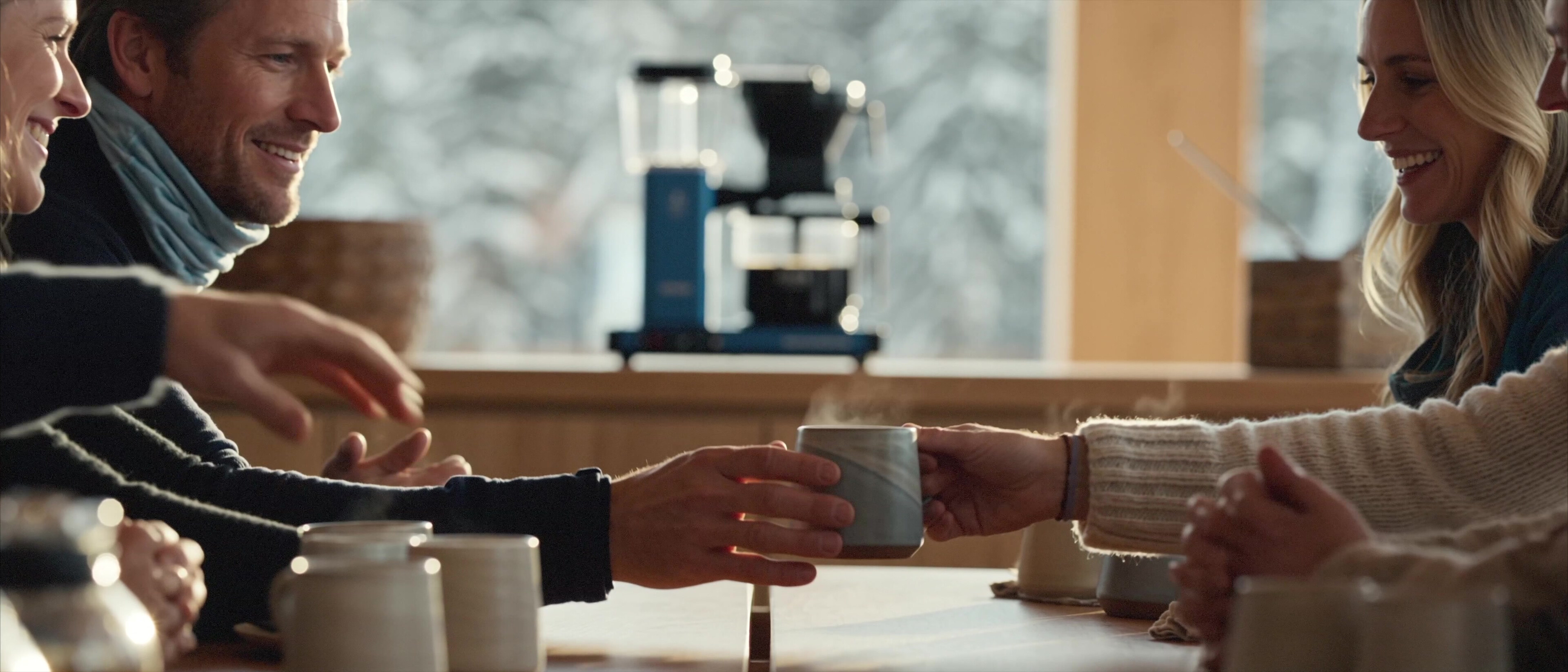 Moccamaster ICE - Friends sharing coffee at the table with the Moccamaster by the window